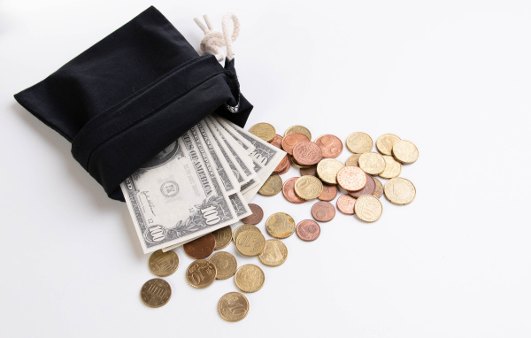 Кошелек с монетами и долларами на белом фоне