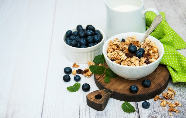 Хлопья с ягодами черники на столе с молоком