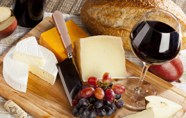 Сыр на столе с виноградом и вином