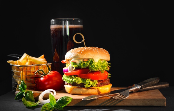 Вкусный аппетитный гамбургер на столе с пивом и картофелем фри