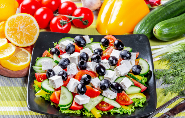 Греческий салат на столе со свежими овощами 