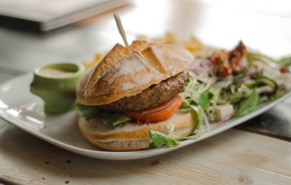 Гамбургер на тарелке с салатом 