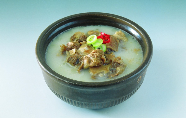 Тарелка супа с говядиной  на голубом фоне