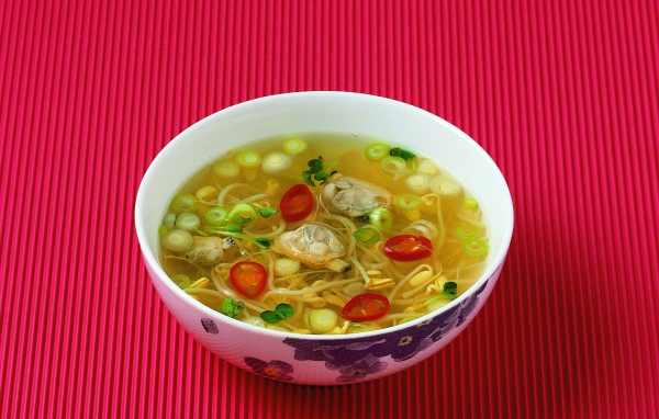 Тарелка супа с морепродуктами на красном фоне
