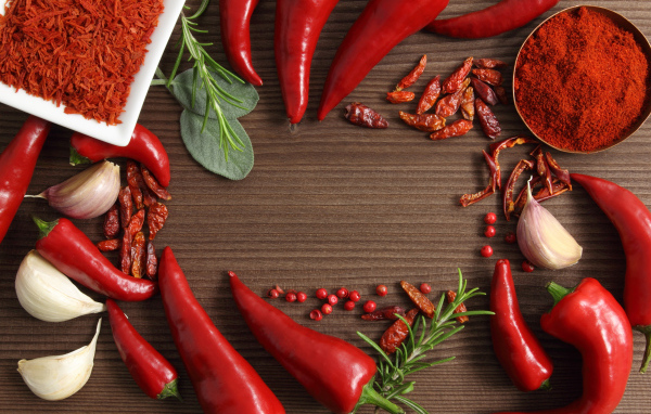 Красный перец с чесноком на деревянном столе