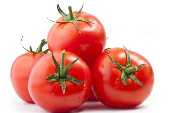 Спелые большие томаты на белом фоне