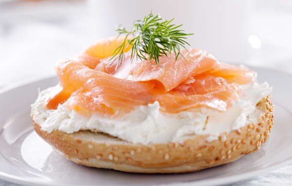 Бутерброд с сыром и красной рыбой на белой тарелке
