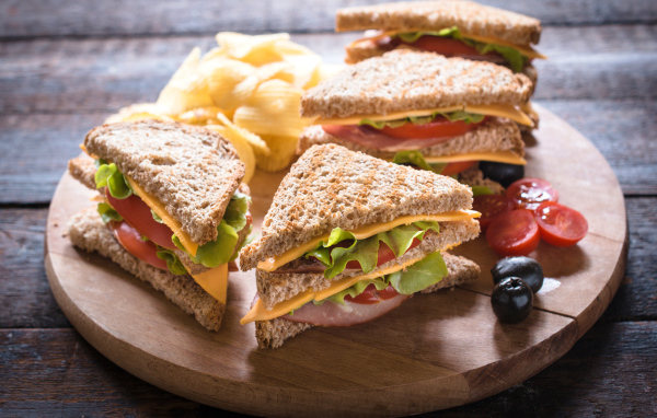 Сэндвичи на деревянной доске с оливками