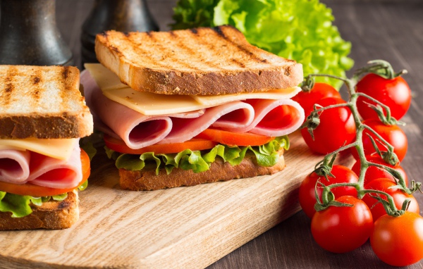 Бутерброды на столе с помидорами и листьями салата