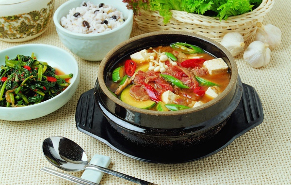 Суп с овощами и мясом на столе с закусками 