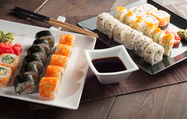 Суши на столе с соевым соусом и палочками