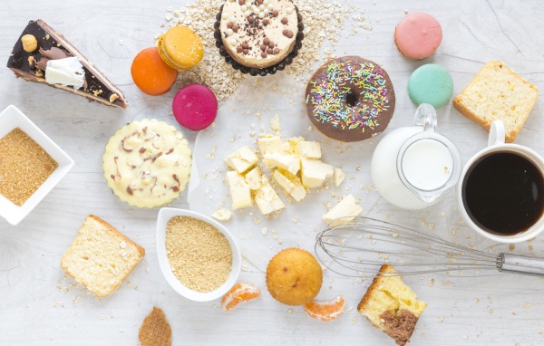 Сладости на столе с молоком и чашкой кофе