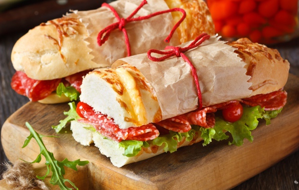 Два огромных бутерброда с колбасой и листьями салата