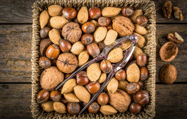 Корзина с разными орехами на столе