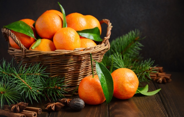 Корзина с мандаринами на столе со специями