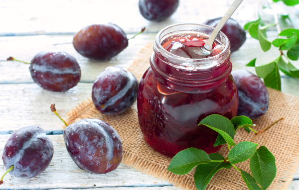 Джем в банке на столе со сливами