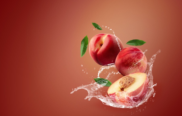 Нектарин в воде на розовом фоне