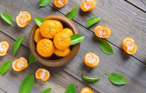 Спелые оранжевые мандарины на деревянном столе вид сверху