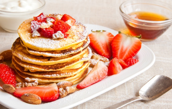 Аппетитные сладкие оладьи с сахарной пудрой и клубникой