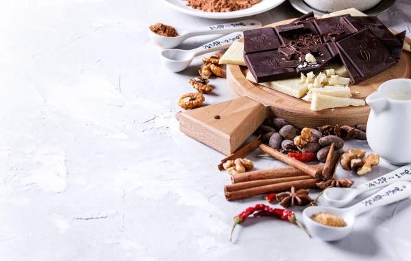 Черный и молочный шоколад на столе с орехами