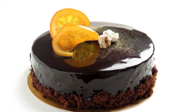 Торт с шоколадной глазурью и апельсинами на белом фоне