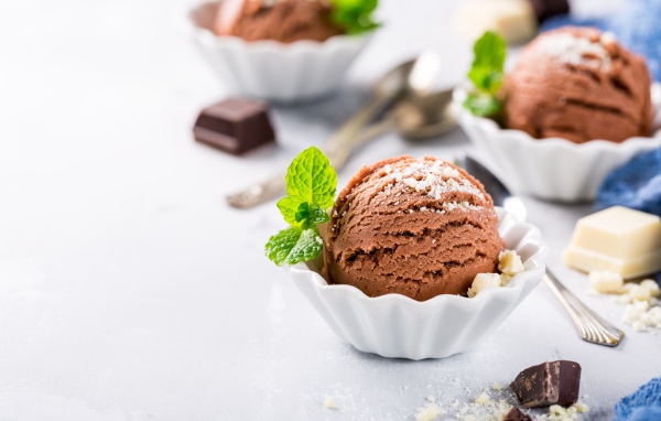 Шарик шоколадного мороженого с мятой на столе с шоколадом