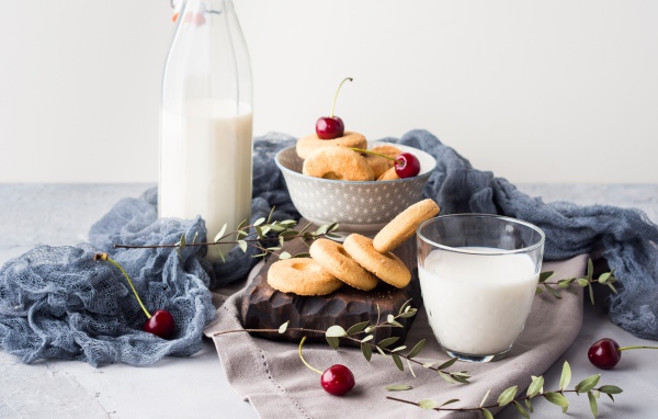 Печенье на столе с молоком и черешней