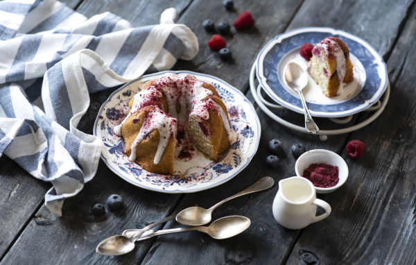 Кекс с кремом и ягодами на столе 