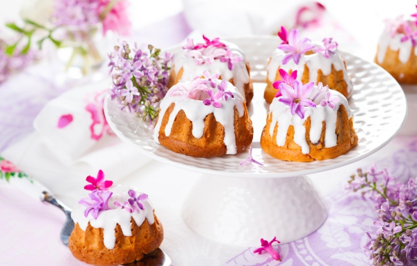 Кексы с глазурью на подносе с цветами сирени 