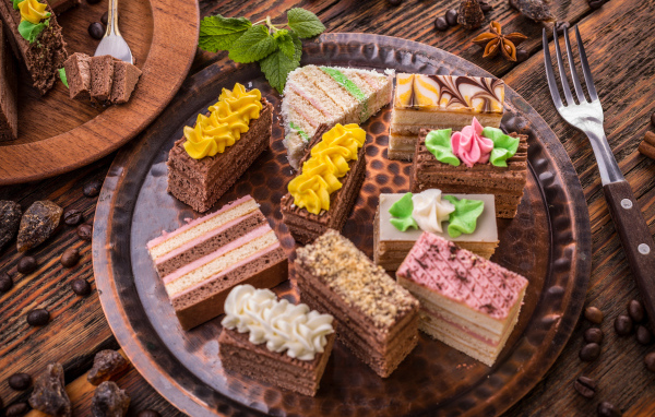 Разные вкусные пирожные на подносе 