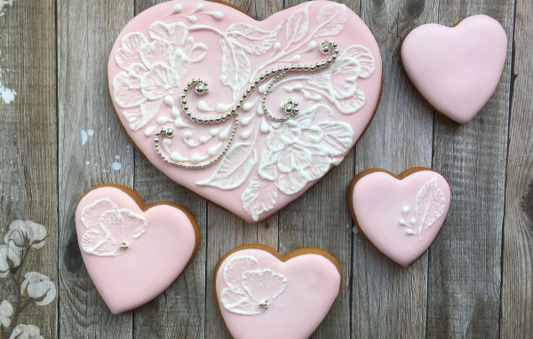 Печенье в форме сердца с розовой глазурью на столе
