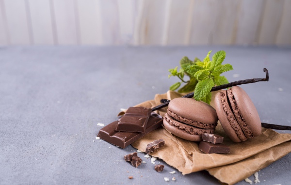 Десерт макарун на столе с шоколадом и ванилью