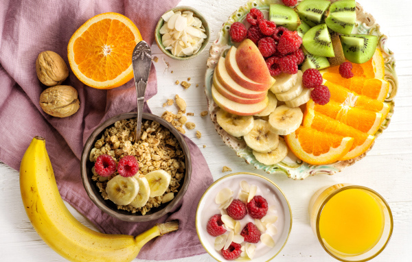 Мюсли на столе фруктами и соком к завтраку