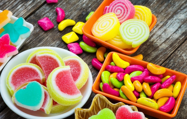Разноцветный мармелад с конфетами на деревянном столе