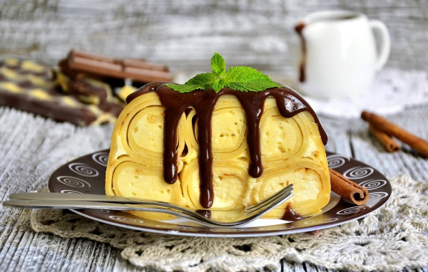 Блинный торт с творогом и шоколадом на тарелке 