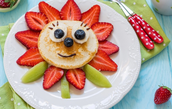 Оладьи с фруктами и ягодами на тарелке