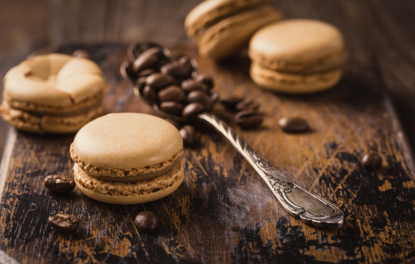 Печенье макарон на столе с ложкой и кофейными зернами