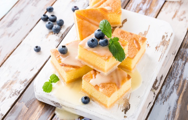 Бисквитные пирожные с сиропом и ягодами черники на столе