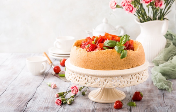 Песочный пирог с клубникой на столе с цветами гвоздики