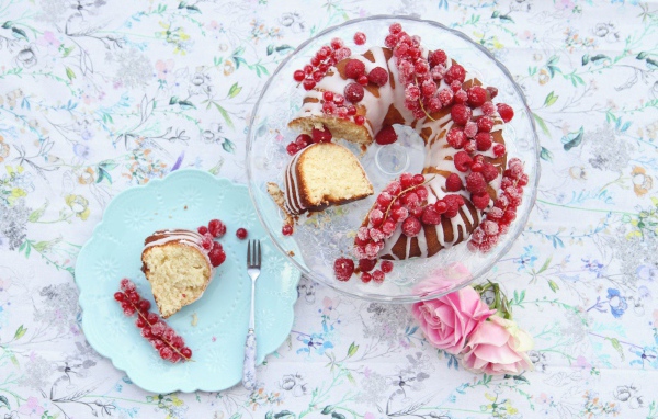 Сладкий кекс с красной смородиной на столе розовыми розами