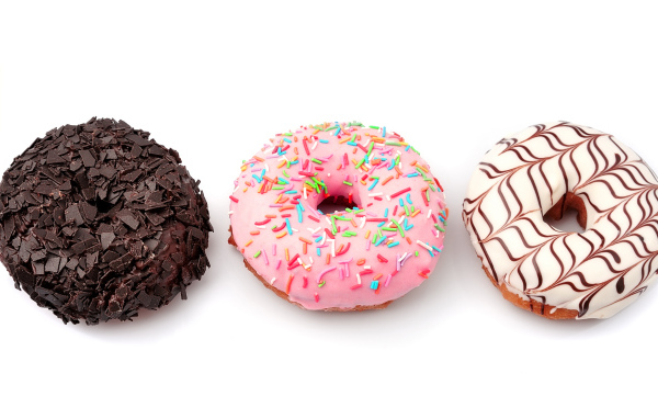 Три аппетитных сладких пончика с глазурью на белом фоне