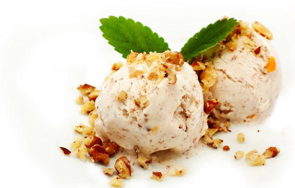 Два шарика мороженого с орехами на белом фоне