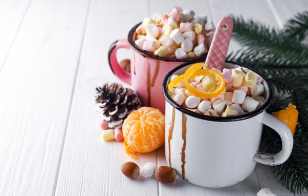 Две железные кружки с маршмеллоу на столе 