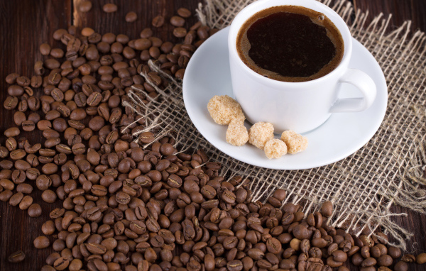 Чашка кофе с зернами на столе 