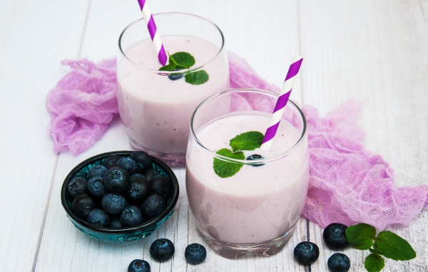 Коктейль в стаканах на столе с ягодами черники