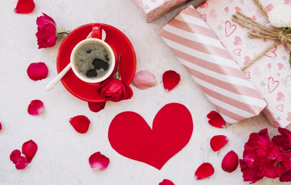 Чашка кофе на столе с подарками и розами