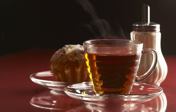 Ароматная чашка горячего чая на столе с кексом