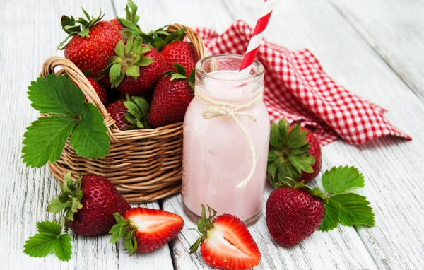 Банка с коктейлем на столе с ягодами клубники