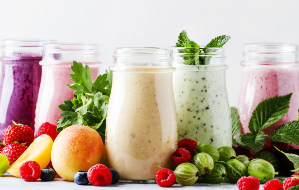 Банки со смузи на столе с ягодами 