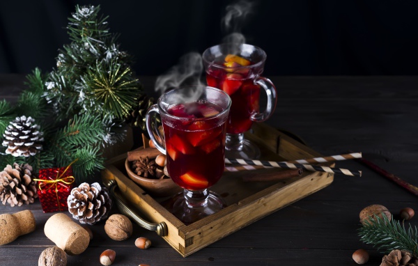 Два стакана горячего глинтвейна на столе с еловой веткой